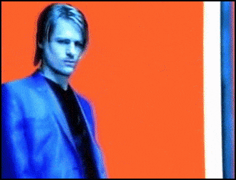 a man in a blue suit is standing in front of an orange and blue background