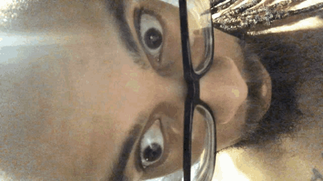 a close up of a person wearing glasses and a beard