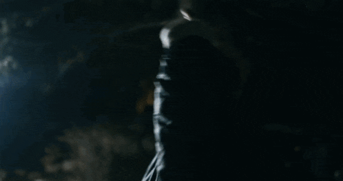 a man in a black jacket is looking up at the sky at night