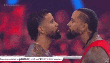 a man with a beard is looking at another man 's face .