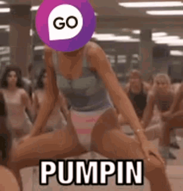 a woman in a swimsuit is dancing in a gym with a purple circle on her head that says go pumpin .