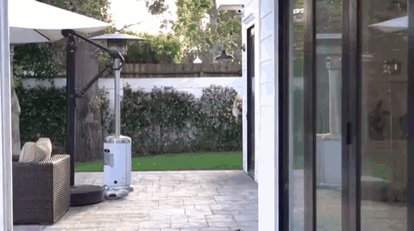 a patio with umbrellas and heaters and a sliding glass door