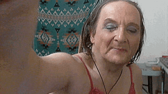 a woman in a red bra is taking a selfie with her eyes closed