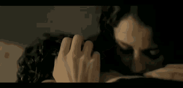 a woman is touching a man 's face in a close up of a movie scene .