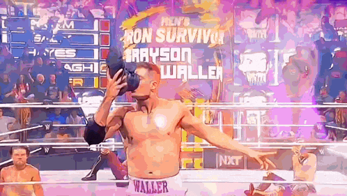 a wrestler is drinking from a bottle in a ring .
