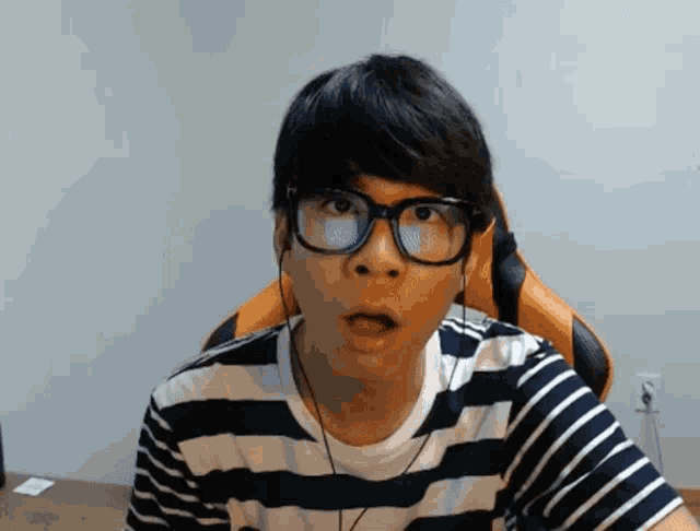 a man wearing glasses and a striped shirt has his mouth open