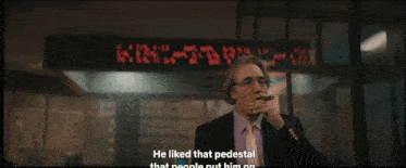 a man in a suit and tie is smoking a cigarette and says he is not more in love with that rovergence