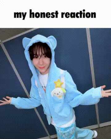a person wearing a blue hoodie with ears is standing in front of a blue wall .