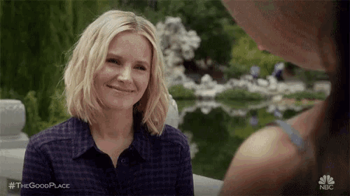 a woman is smiling at another woman in a park .