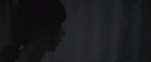 a close up of a woman looking out of a window with her eyes closed .