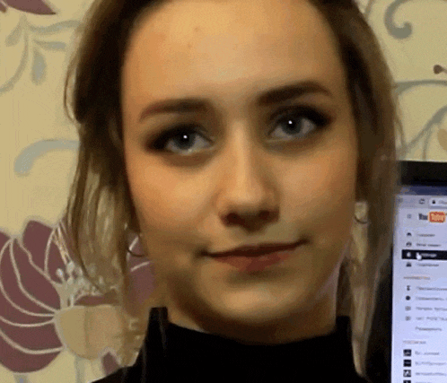 a close up of a woman 's face in front of a screen that says youtube on it