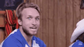 a man wearing a blue and white shirt is smiling