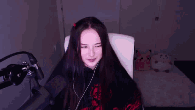 a woman sitting in front of a microphone wearing a hoodie that says ' i love you ' on it