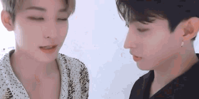 two young men are looking at each other with their eyes closed and their mouths open .