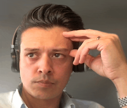 a man wearing headphones holds his hand to his head