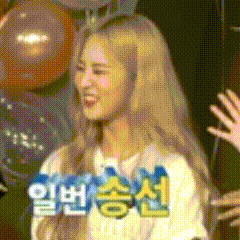 a woman with blonde hair is smiling in front of balloons and a sign that says ' korean ' on it .