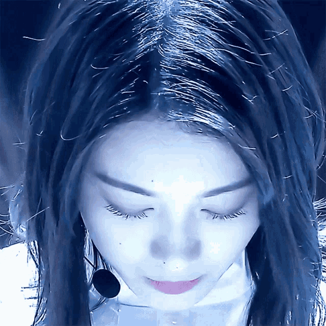 a close up of a woman 's face with her eyes closed and a microphone around her neck