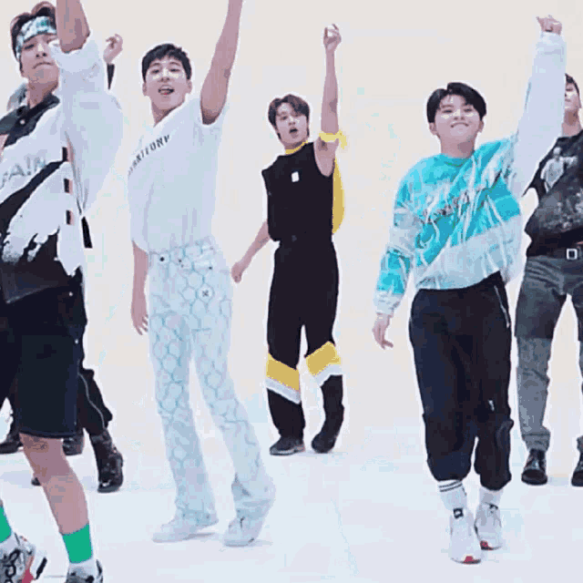 a group of young men are dancing and one of them is wearing a t-shirt that says territory