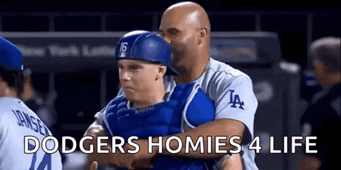 a man is holding a baseball player in his arms with the words dodgers homies 4 life written on the bottom .