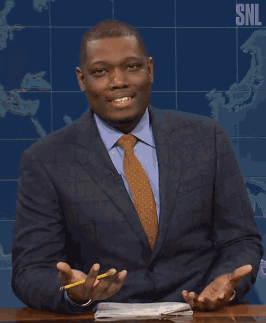 a man in a suit and tie holds a yellow pencil in front of a snl sign