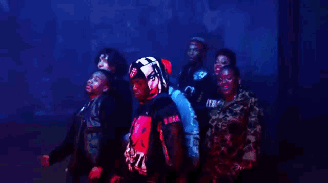 a group of people are standing in a dark room in a foggy room .