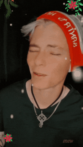 a man wearing a santa hat and a sdsw necklace with his eyes closed