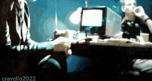 a blurry picture of two people sitting at a table with cravello2022 written on the bottom right