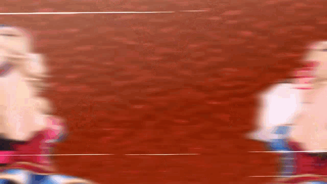 a blurry picture of a couple of people standing next to each other on a red background .