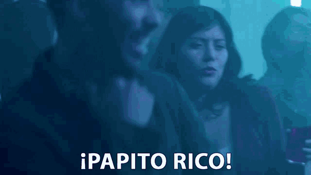 a blurred image of a group of people with the words papito rico in white
