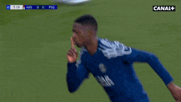 a soccer player is blowing a kiss while wearing a blue shirt that says jak