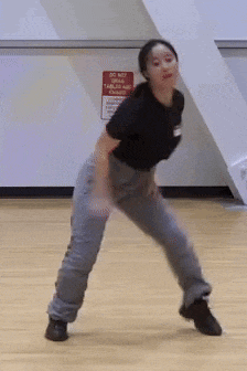 a woman dancing in front of a sign that says do not enter