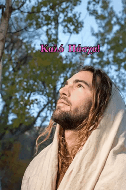 a man with long hair and a beard is wrapped in a white blanket with the words kolo paoya in pink letters
