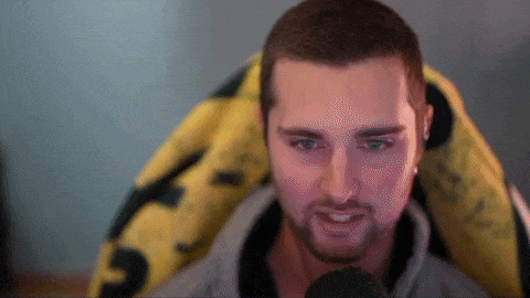 a man with a beard is sitting in front of a microphone