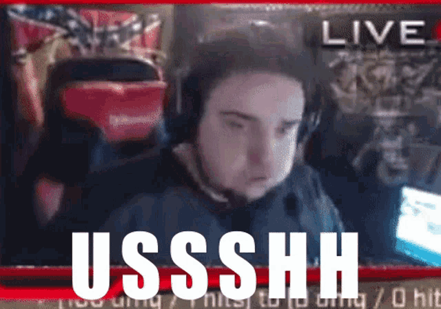 a man wearing headphones is sitting in front of a screen that says live