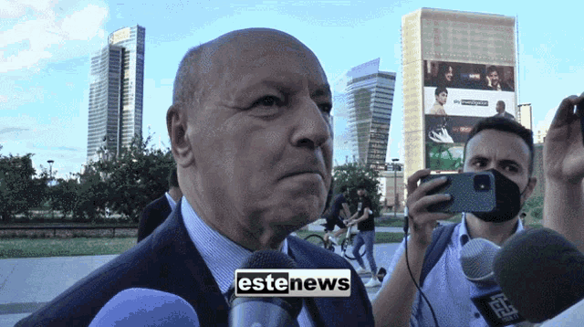 a man in a suit is being interviewed by a reporter for estenews