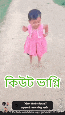 a little girl in a pink dress is standing on a dirt road with the words your device does n't support recording state