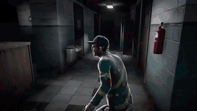 a man walking down a hallway with a fire extinguisher hanging on the wall