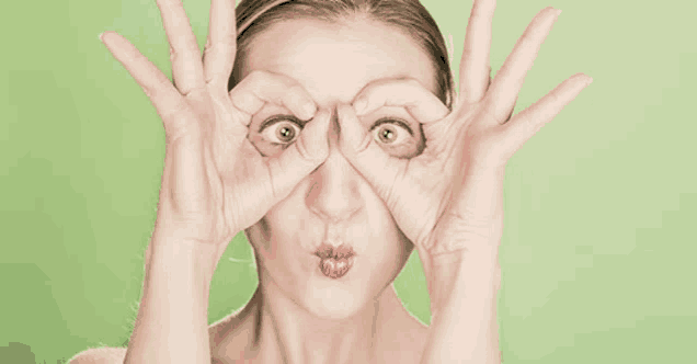 a woman making a funny face with her hands covering her eyes