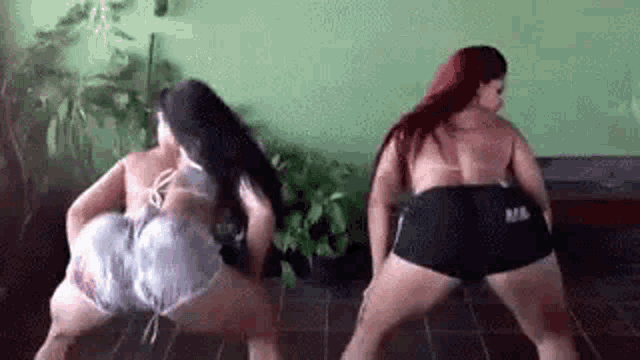 two women are dancing on a tiled floor .