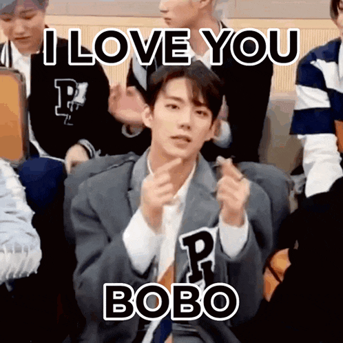 a man in a suit is making a heart shape with his hands and says i love you bobo .