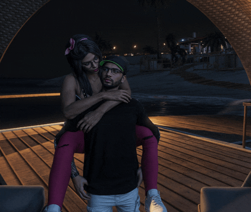 a man is carrying a woman on his shoulders on a dock at night
