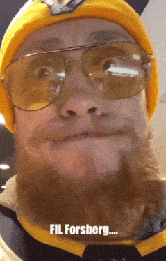 a man with a beard wearing sunglasses and a yellow hat says fil forsberg on the bottom