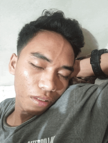 a man wearing a caterpillar t-shirt is sleeping