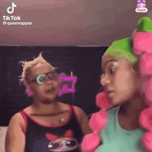 two women are standing next to each other and talking to each other in a room .