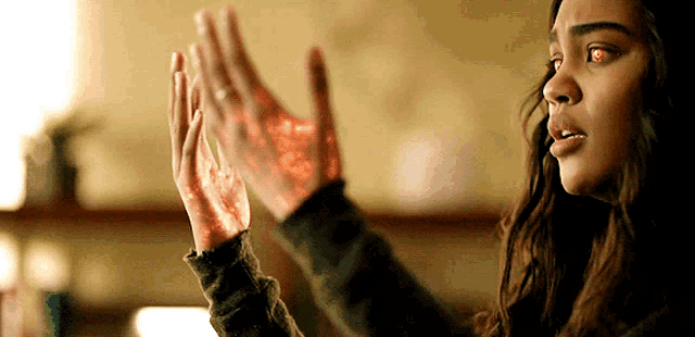 a woman with red eyes is holding her hands together