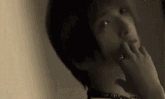 a close up of a person 's face with their hand on their chin .