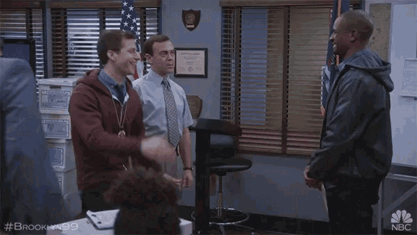 a group of men are hugging in a room with a nbc logo on the bottom