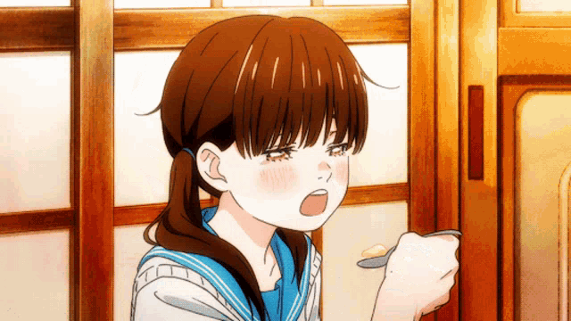 a girl in a school uniform is holding a spoon in her hand