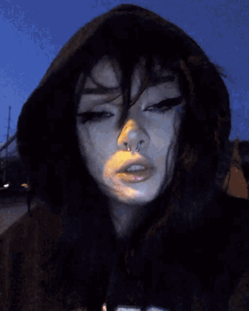 a close up of a woman 's face with a yellow object in her hand