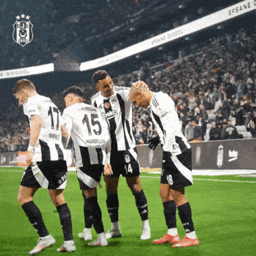 a group of soccer players on a field one of whom has the number 15 on his jersey